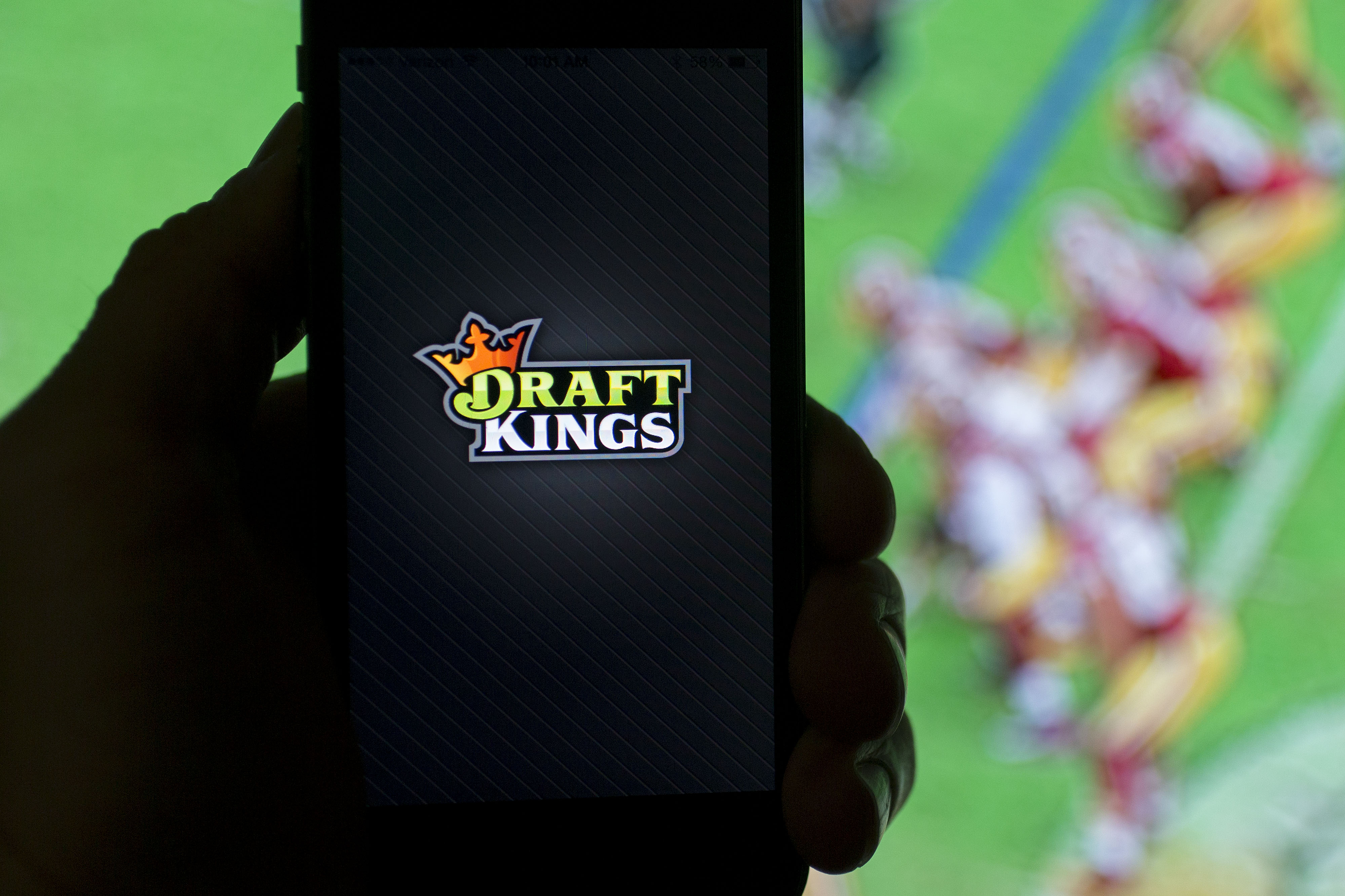The DraftKings Inc. logo is arranged for a photograph on an Apple Inc. iPhone in Washington, D.C., U.S., on Sunday, Oct. 4, 2015. Fantasy sports companies DraftKings Inc. and FanDuel Inc. raised a total of $575 million in July from investors including KKR & Co., 21st Century Fox Inc. and Major League Baseball to attract players to games that pay out millions of dollars in cash prizes in daily contests. Photographer: Andrew Harrer/Bloomberg via Getty Images
